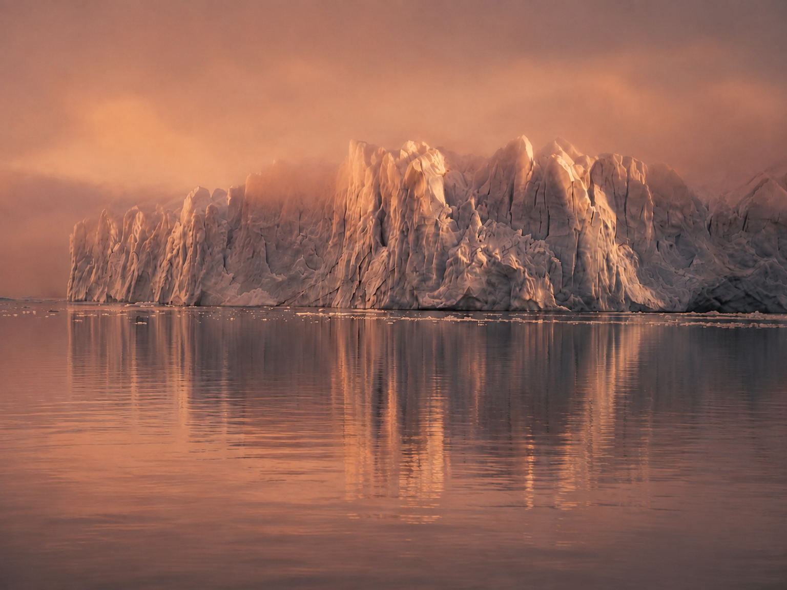 Glacier landscape with ice and water under low evening light.